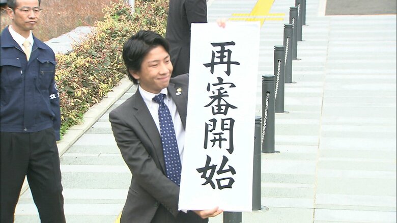 「再審開始」と掲げる弁護人（2014年）