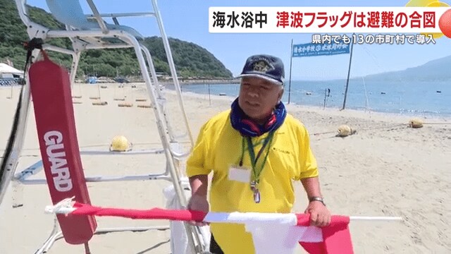 津波フラッグを手に説明する監視員