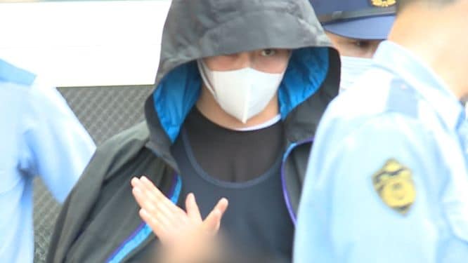佐藤容疑者が見せた謎のポーズ ※画像は一部加工