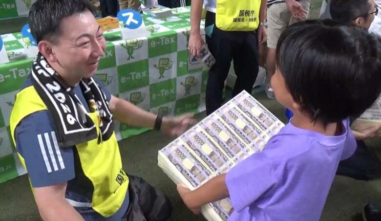 日本サッカー協会と国税局がコラボイベント 紙幣1億円分の重さを体感した子供「1億円を納められるようになりたい」｜FNNプライムオンライン