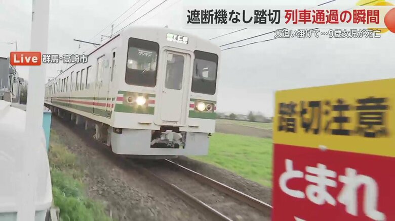 中継中に現場の踏切を走行する上信電鉄の車両