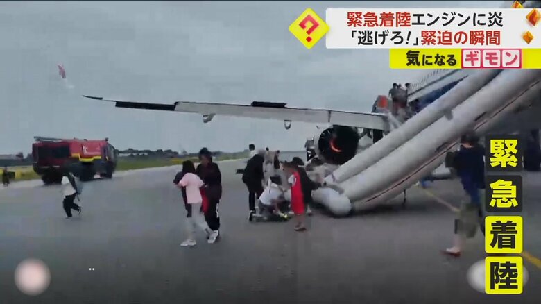 緊急着陸し、機内から逃げ出す人々