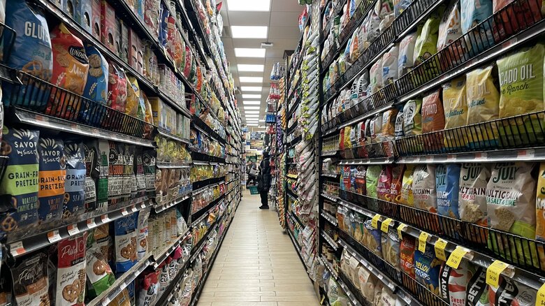 床から天井まで商品棚に品物が並ぶスーパー店内