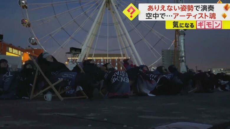 毛布にくるまり、ピアノの演奏に聞き入る観客たち