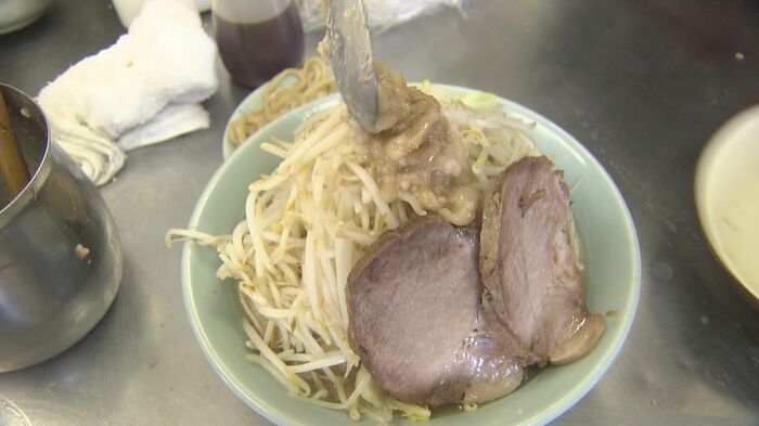 極太麺の上に山盛りのモヤシにキャベツ。”二郎系ラーメン”を盛り付ける(あつ美二号・長野市)