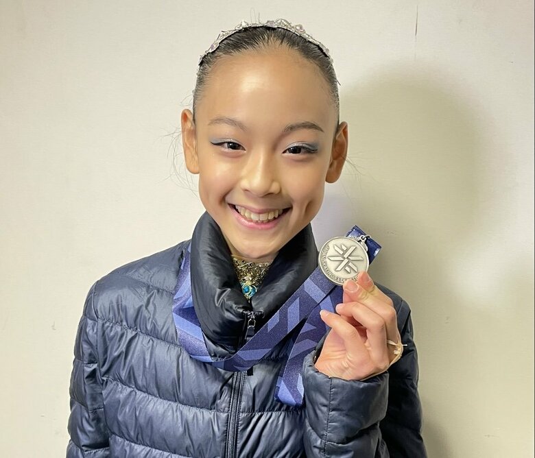 メダルを手に笑顔を見せる岡万佑子