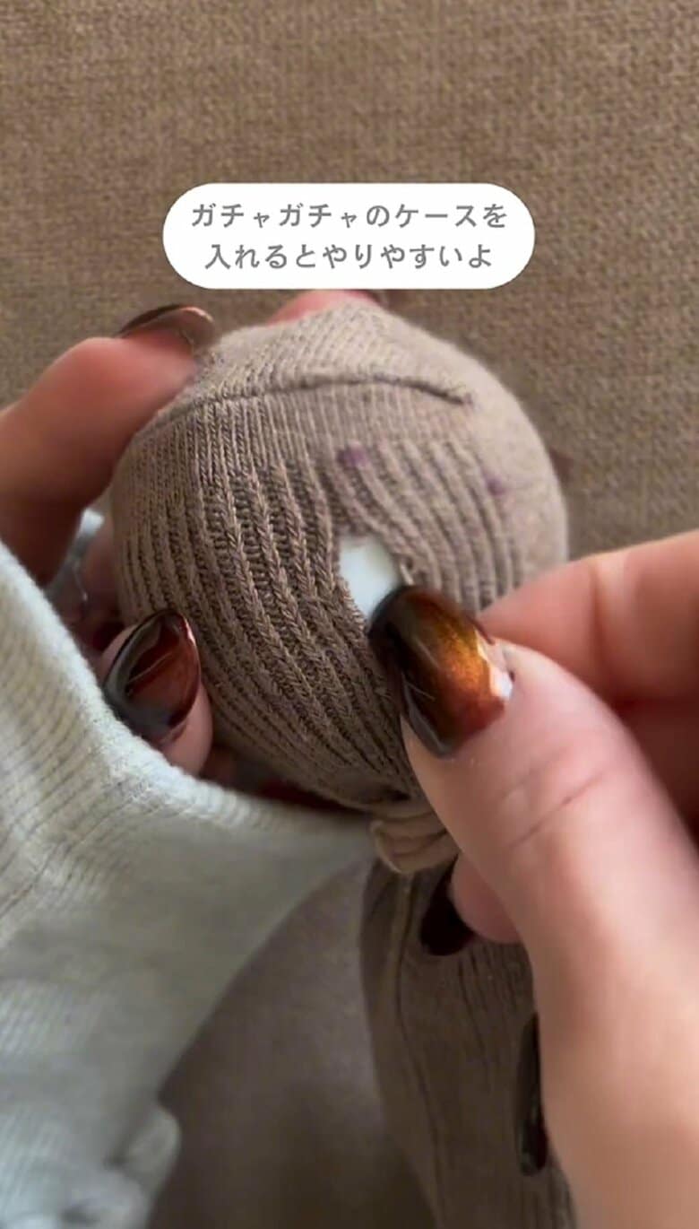 靴下の中にカプセルトイの容器を入れてヘアゴムで固定