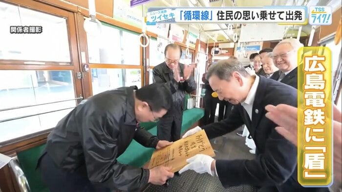 広島電鉄に盾を手渡す岡野泰明さん
