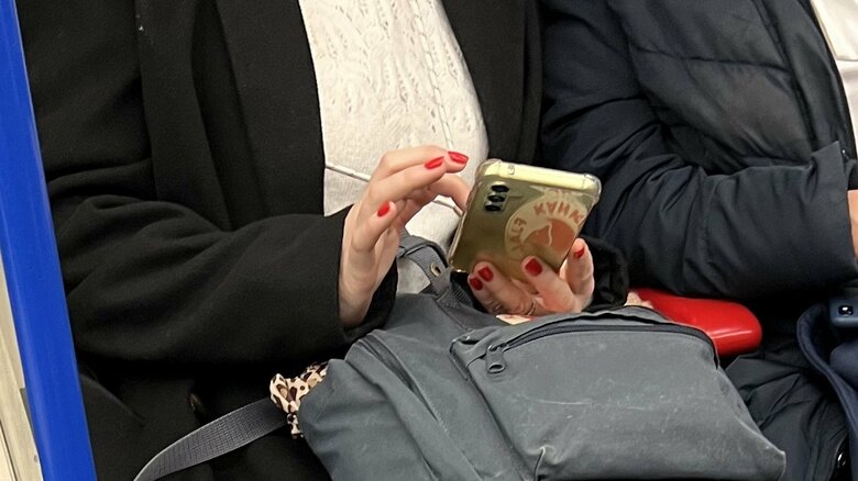 地下鉄でスマホを使用する人。ネットは使えない。