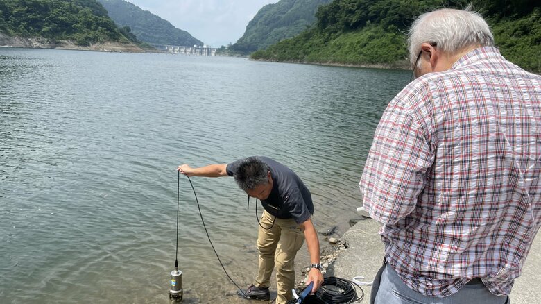 浦山ダムで計測機を用いて水質調査する様子