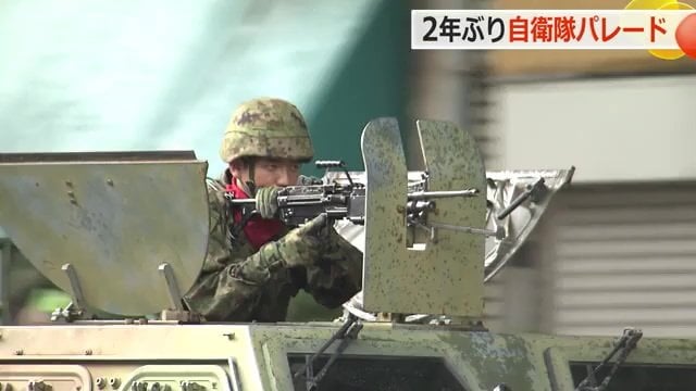 戦闘機の上で銃を構える隊員