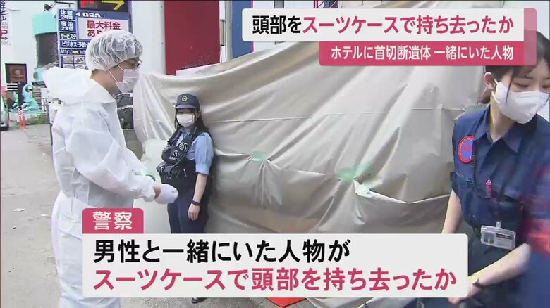 防カメには、男性と共に大型のスーツケースを持った人物が映っていた