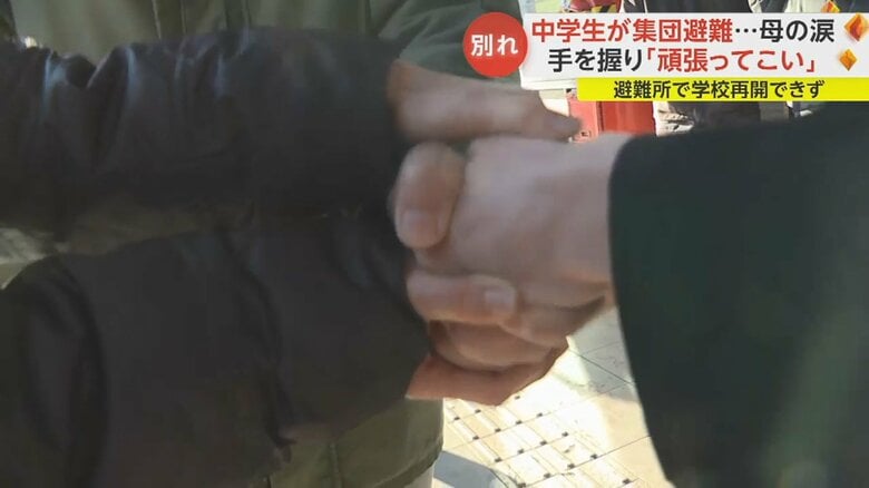 固く手を握り合った小住さん親子