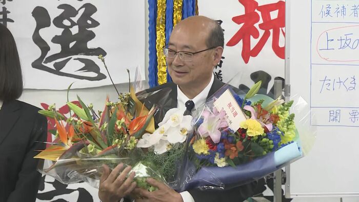 支援者から花束を受け取り笑顔を見せる上坂さん（12日）