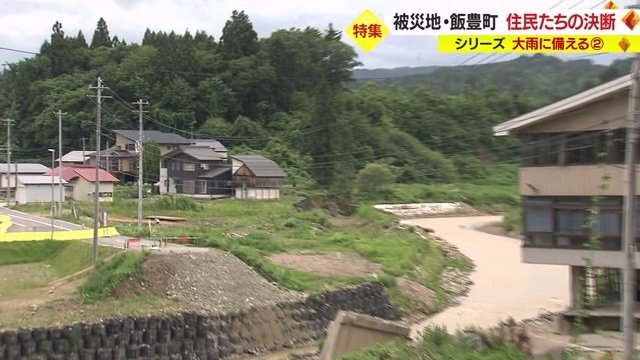 小白川(右)のそばにある舩山さんの自宅(左の黒い家屋)