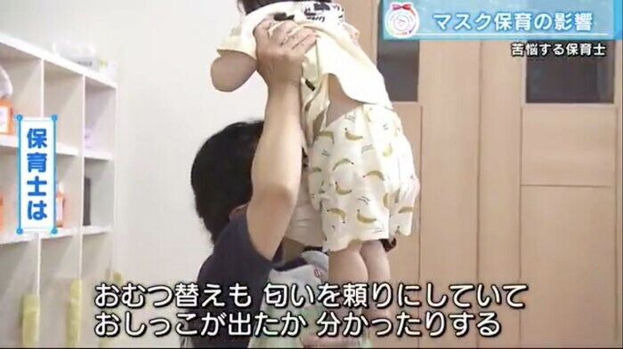 子どものおむつのにおいを確認する保育士