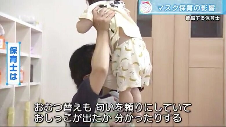 子どものおむつのにおいを確認する保育士
