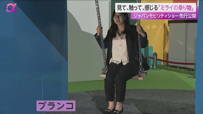 ブランコをこぐ記者。ブランコで発電し、水素を生成する展示だ