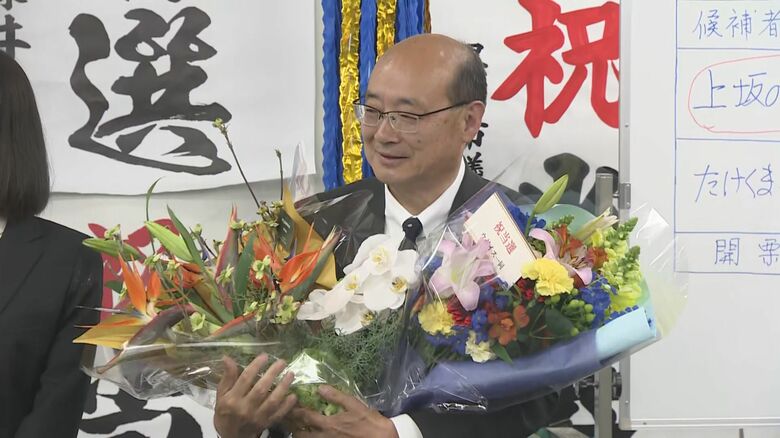 支援者から花束を受け取り笑顔を見せる上坂さん（12日）