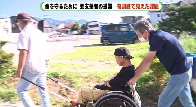 補助具を装着した車いすで避難