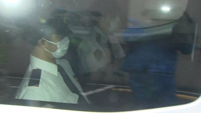 警察車両の中で、岡田容疑者は、脚の間に顔をうずめていた。