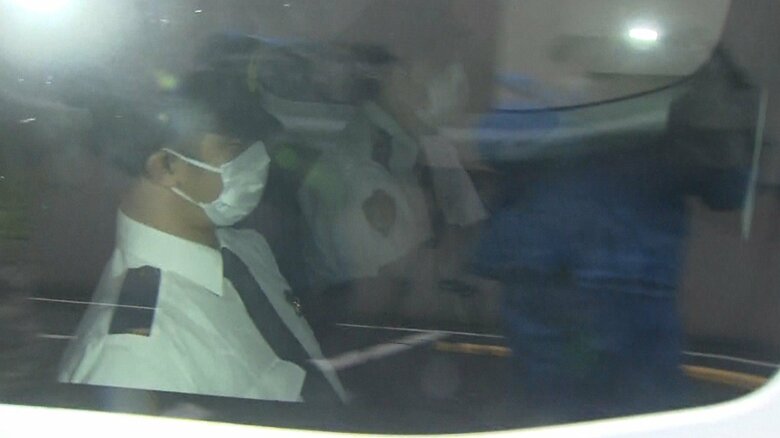 警察車両の中で、岡田容疑者は、脚の間に顔をうずめていた。