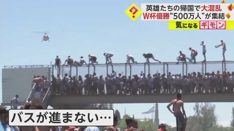 バスに飛び乗るためか、橋の上に並んで立つ人たち