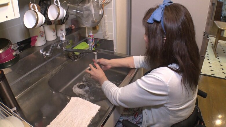 車いすに乗った状態で家事をする中林さん