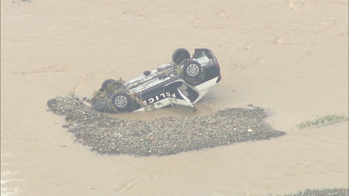 山形・秋田で記録的な大雨 パトカーは暗い中で道路を横切る濁流に