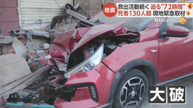 建物の屋根の一部が崩れ、その下に止めてあった車が大きく破損
