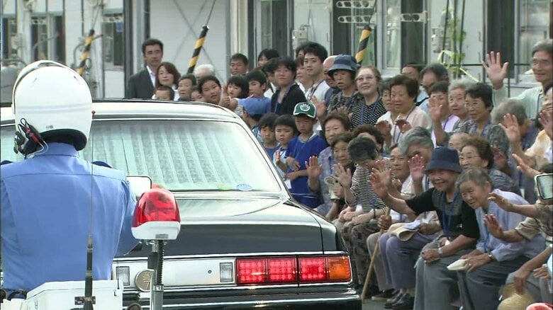 両陛下が乗られた車を見送る被災者たち