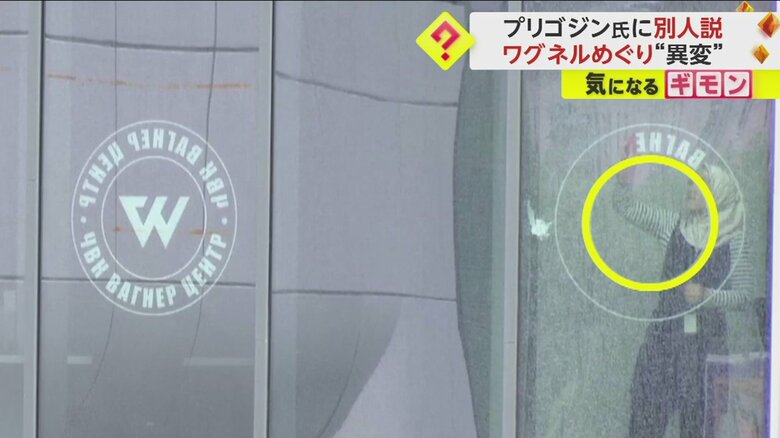 窓に貼られた「ワグネル」のロゴマークや頭文字を剥がす女性