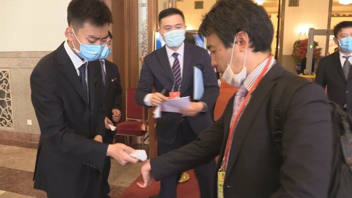 体温検査を受ける記者