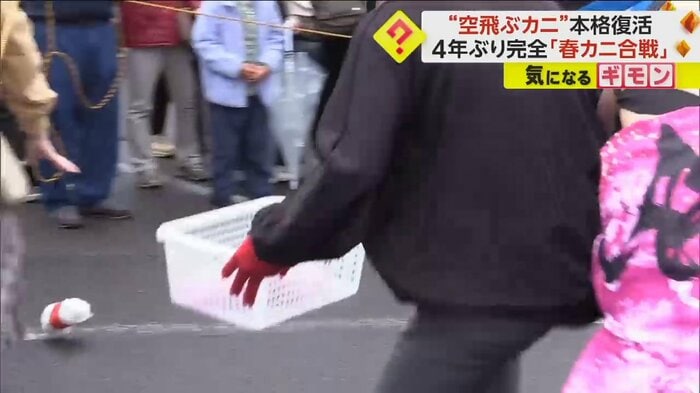 地面に転がったカニを追いかける来場者
