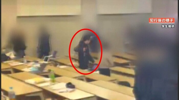 何かを床にたたきつけるユ容疑者(画面中央)と避難する学生ら