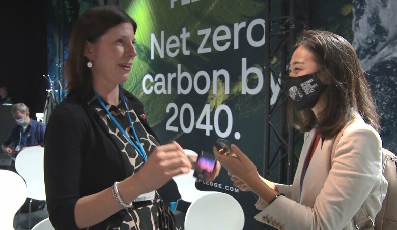 環境投資の専門家と話す佐座さん（右）　11月3日COP会場にて