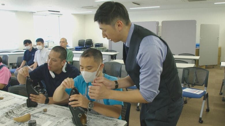 伊藤忠の子会社のスタッフに靴磨きを教える木村さん