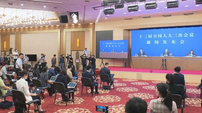 別の場所にいる報道官と中継を繋ぎ、記者は間隔を空けて座っていた