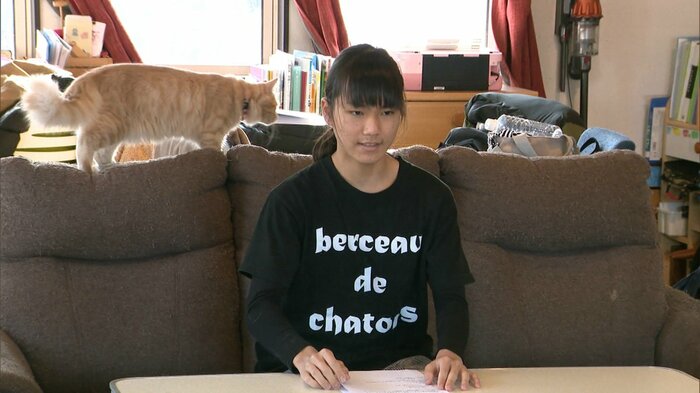 赤石さんの後ろをネコが悠然と…