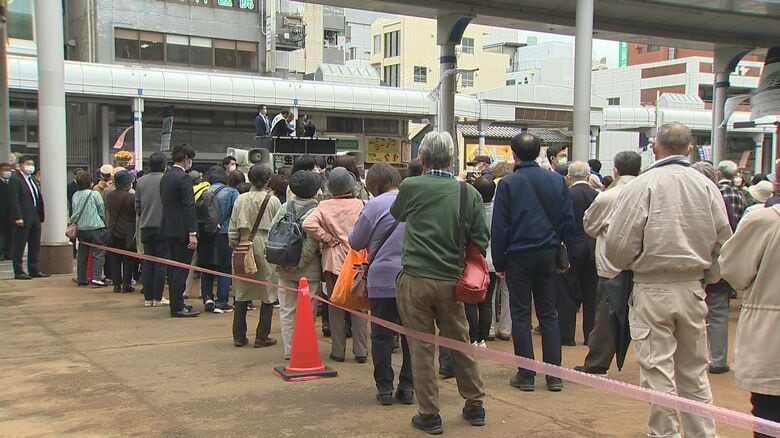 赤いテープ内で演説を聴く聴衆