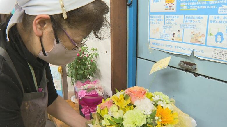 客から花束を渡される佐藤秀美さん