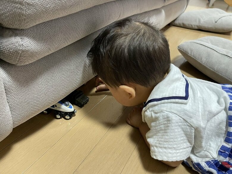 ソファ下におもちゃを入れる10カ月の次男くん