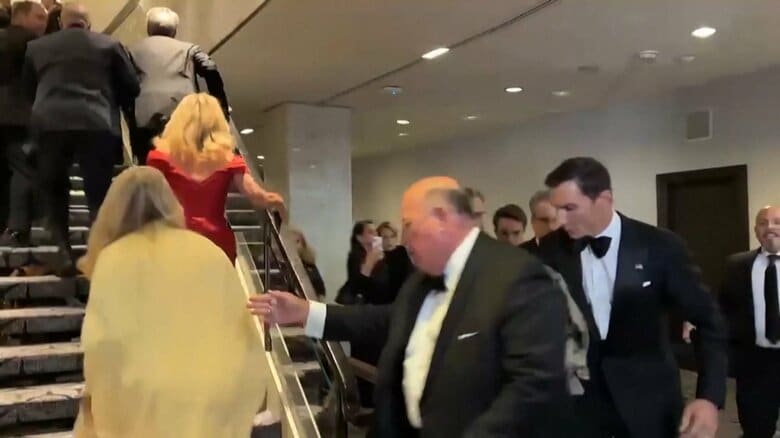 会場から避難する出席者たち