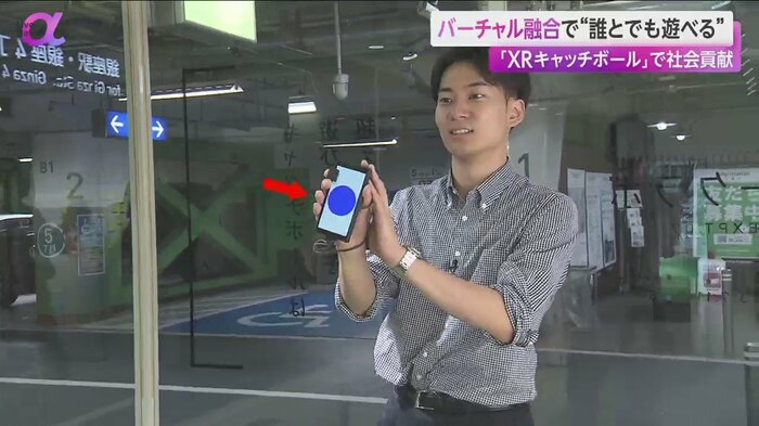 手には青い丸が表示されたスマホを持っている