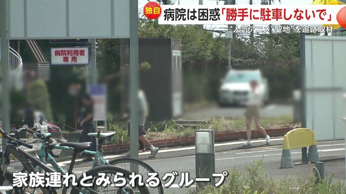 病院の駐車場に車を止めた家族とみられるグループ