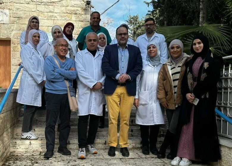 エルサレム旧市街の診療所前でUNRWA職員と清田さん（1月25日)