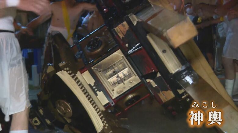 地面にたたきつけられ傾いたみこし