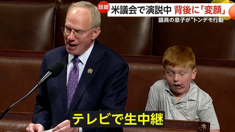 熱弁を振るうジョン・ローズ下院議員の後ろで変顔を見せるガイくん