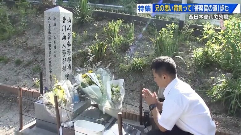 殉職の慰霊碑に手を合わせる賢也さん