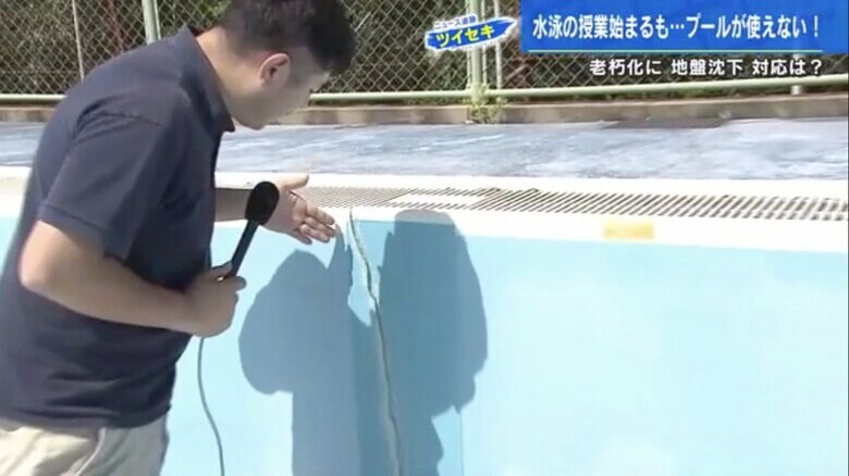 プール壁面のひび割れをリポートする鈴木崇義記者